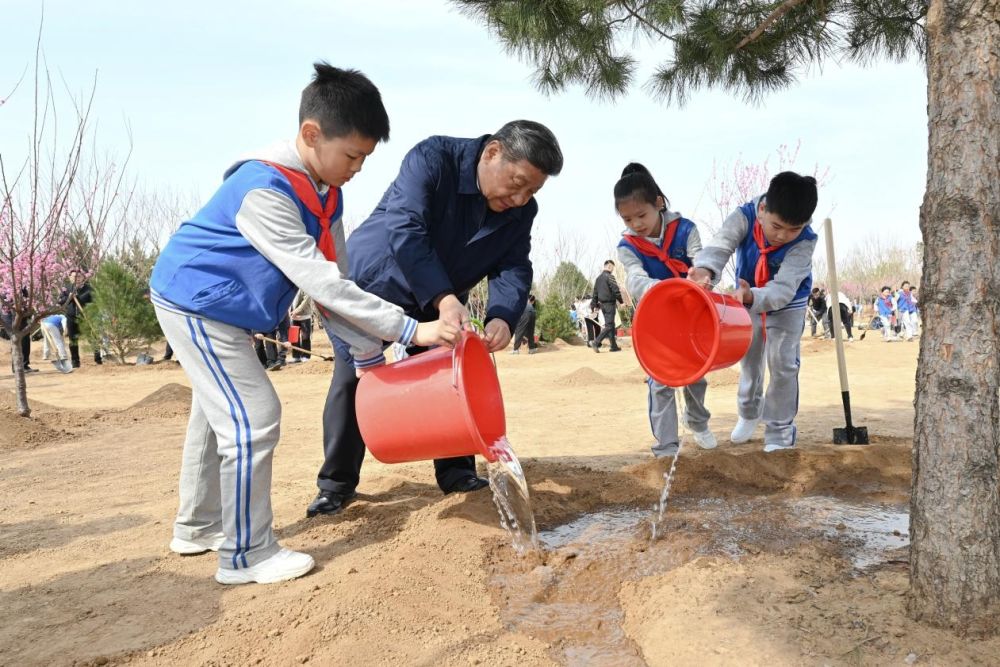 2025年4月3日，習(xí)近平總書(shū)記等來(lái)到北京市豐臺(tái)區(qū)永定河畔參加首都義務(wù)植樹(shù)活動(dòng)。這是習(xí)近平總書(shū)記同少先隊(duì)員一起給剛栽下的樹(shù)苗澆水。新華社記者 謝環(huán)馳 攝